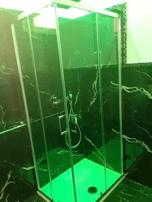 a shower with a glass enclosure with a green floor at Suite Nobile in Palermo