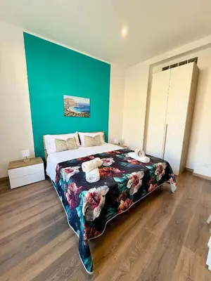 a bedroom with a large bed with a blue wall at 30House in Palermo