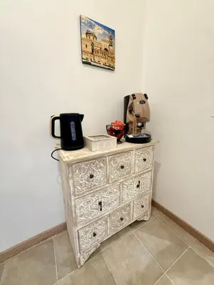 a dresser with a coffee maker on top of it at 30House in Palermo