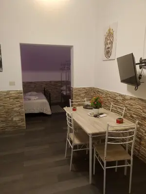 a dining room with a table and chairs and a bedroom at La casetta di Barbara in Palermo