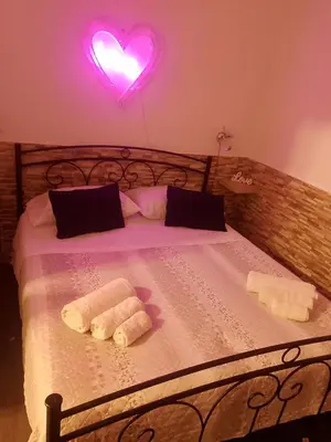 a bedroom with a bed with two towels and a heart light at La casetta di Barbara in Palermo