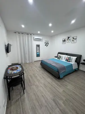a bedroom with a bed and a table in it at Cristofarohome2 in Palermo