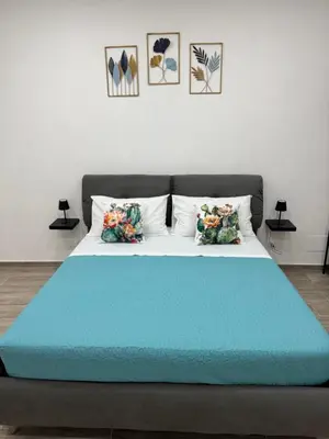 a bed with a blue blanket on top of it at Cristofarohome2 in Palermo