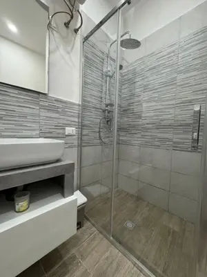 a bathroom with a glass shower and a sink at Cristofarohome2 in Palermo