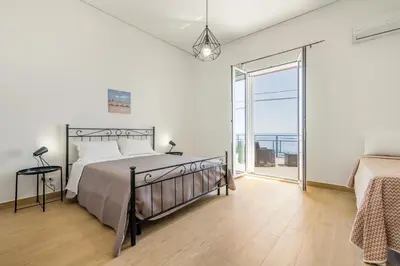 a bedroom with a bed and a large window at GuestHost - Seaview Apartments near Palermo in Palermo