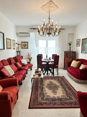 a living room with red couches and a table at Casa Mirella in Aspra