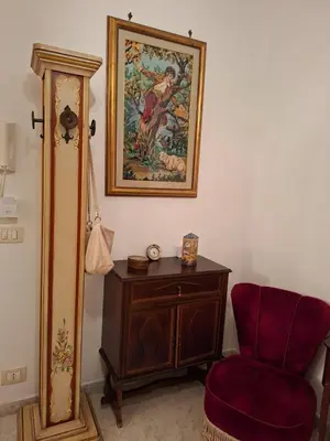 a room with a chair and a painting on the wall at Casa Mirella in Aspra