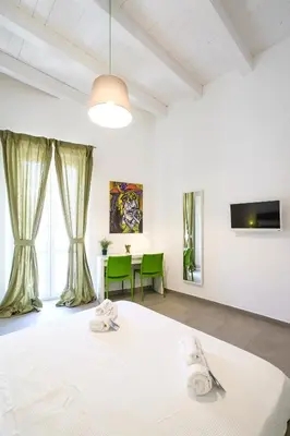 a room with a white bed and a table at B&B Cala Peppa in Palermo