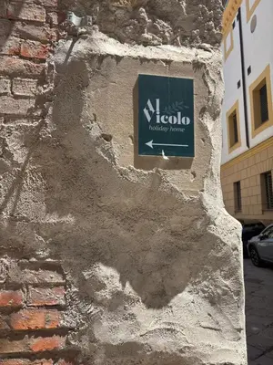 a sign on the side of a brick building at Al vicolo holiday home in Palermo