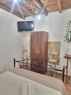 a bedroom with a bed with a tv on the wall at Al vicolo holiday home in Palermo