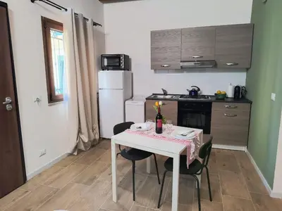 a small kitchen with a white table and chairs at La Casetta di Lilla in Palermo
