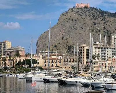 a bunch of boats docked in a harbor with a mountain at La Casetta di Lilla in Palermo