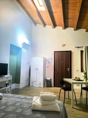 a room with a table and a desk and a table and chairs at La Casetta di Lilla in Palermo