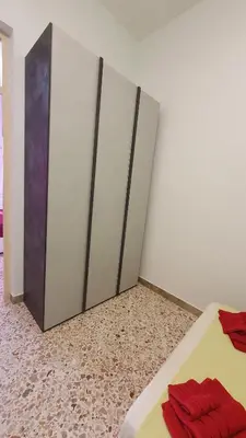 a bedroom with three wardrobes with red towels on a bed at Casa Nonna Rosa in Balestrate