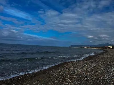 a rocky beach with the ocean on a cloudy day at Summer House in Buonfornello