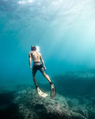 a man standing on a surfboard in the water at Appartamento vicino Palermo - 2 bedr in Trabia in Trabia
