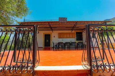 an iron gate to a patio with a table and chairs at villa ulivo rovetto in Mandra Capreria