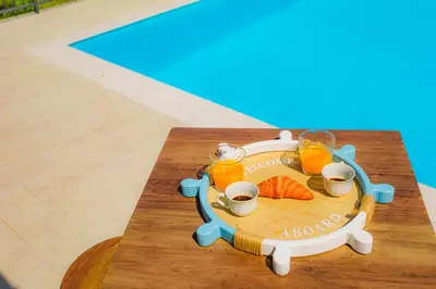 a table with three glasses of orange juice and sushi at villa ulivo rovetto in Mandra Capreria