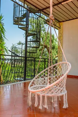 a rattan swing hanging from a porch at villa ulivo rovetto in Mandra Capreria