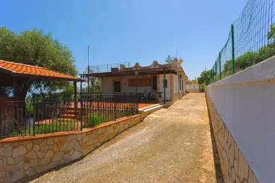 a small house on a street next to a building at villa ulivo rovetto in Mandra Capreria