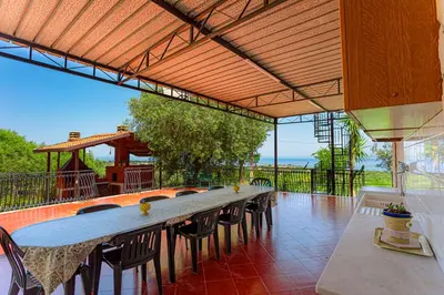 a long table and chairs on a patio at villa ulivo rovetto in Mandra Capreria