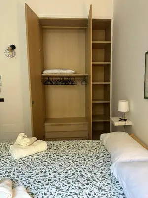 a bedroom with two beds and a closet at La finestra sugli archi in Palermo