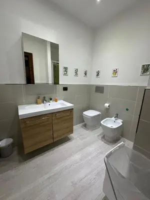 a bathroom with a sink and a toilet and a mirror at La finestra sugli archi in Palermo