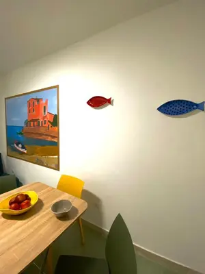 a dining room with a table and a painting of fishes on the wall at Casimiro in Porticello