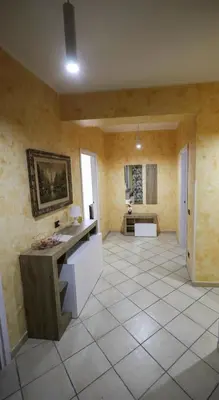 a large room with a tile floor and a bathroom at appartamento san felice in Bagheria