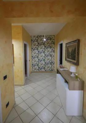 a hallway with a tile floor and a wall at appartamento san felice in Bagheria
