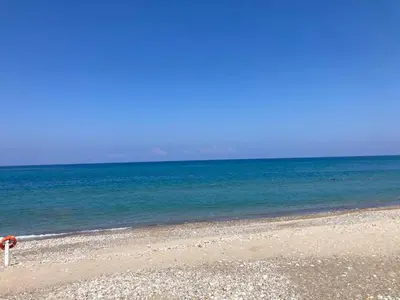 a person sitting on a beach near the ocean at Casa Marina in Buonfornello