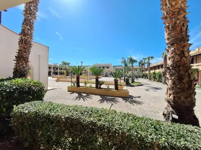 a park with palm trees and bushes in a courtyard at Casa Marina in Buonfornello