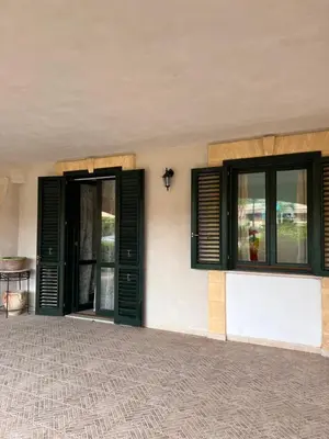 a building with green doors and windows on it at Casa Marina in Buonfornello
