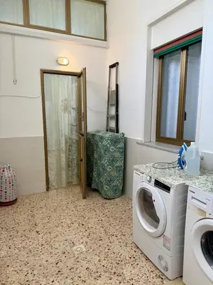 a laundry room with a washing machine and a door at Piccolo Brasile Home in Capaci