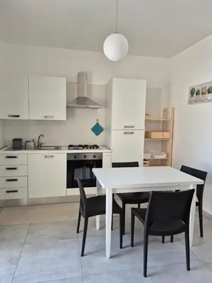 a kitchen with a white table and black chairs at ammare da mari in Castellammare del Golfo