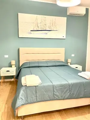 a bedroom with a blue bed with two towels on it at Toselli 32 in Palermo