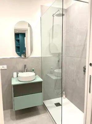 a bathroom with a glass shower and a sink at Toselli 32 in Palermo