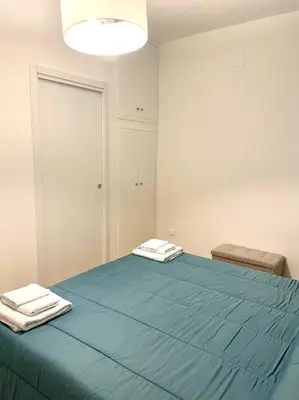 a bedroom with a large blue bed with two towels at Toselli 32 in Palermo