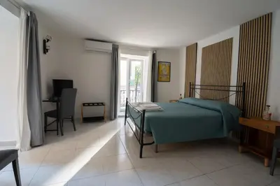 a bedroom with a bed and a table and a window at A Calat'i Jurici in Palermo