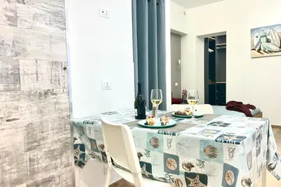 a dining room table with two glasses of wine at Due passi dal castello a mare in Castellammare del Golfo