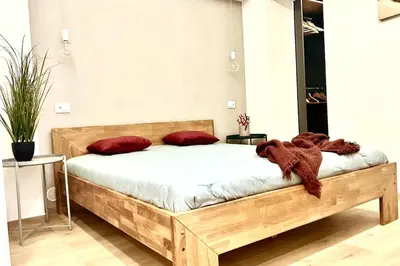 a wooden bed with red pillows and a teddy bear on it at Due passi dal castello a mare in Castellammare del Golfo