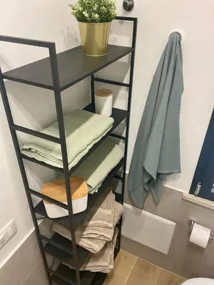 a shelf with towels and a plant in a bathroom at Due passi dal castello a mare in Castellammare del Golfo