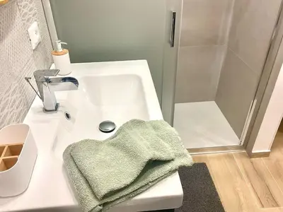 a bathroom with a white sink and a shower at Due passi dal castello a mare in Castellammare del Golfo
