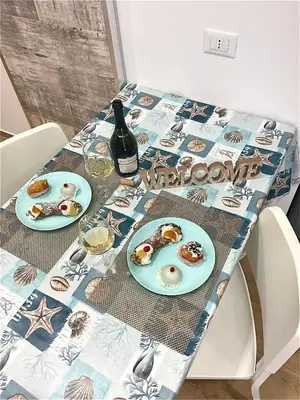 a table with two plates of food and a bottle of wine at Due passi dal castello a mare in Castellammare del Golfo