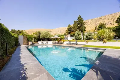 a swimming pool in a yard with mountains in the background at Ibis Lodge With Swimming Pool in Palermo