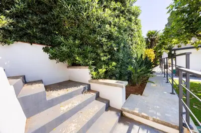 a set of stairs with a bush next to a fence at Ibis Lodge With Swimming Pool in Palermo