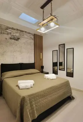 a bedroom with a large bed with two towels on it at Teatro Massimo Terrace relax suite in Palermo