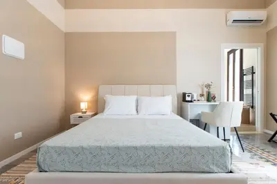 a bedroom with a bed and a desk and a chair at Giardino Segreto - Affitta Camere in Castellammare del Golfo
