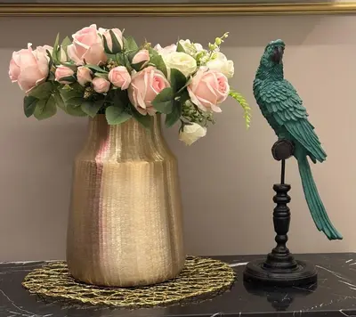 a vase with pink roses and a bird on a table at Giardino Segreto - Affitta Camere in Castellammare del Golfo