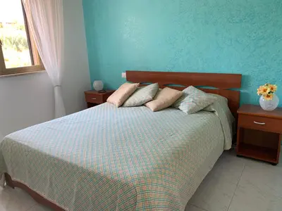 a bedroom with a bed with a blue wall at Appartamento Citreum in Balestrate